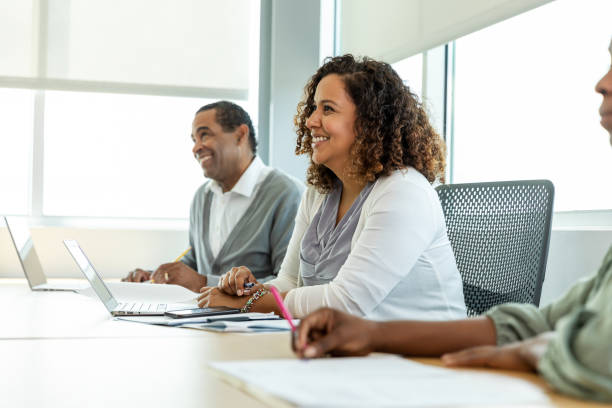 istock Smiling Diverse Adults in a Business Meeting Using Laptops 2194401532