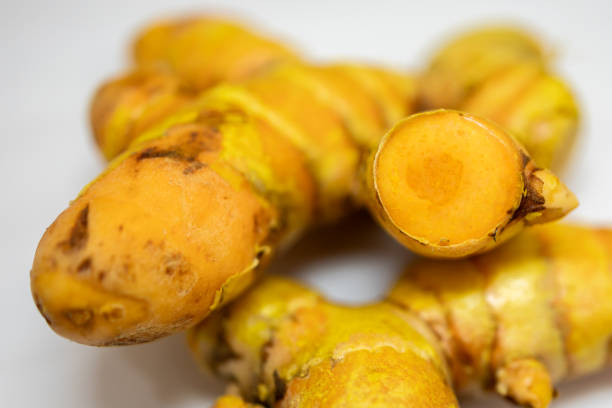 fresh raw turmeric close-up studio shot on blurred white background