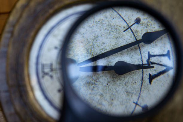 time concept with an old wall clock and a magnifying glass highlighting a detail
