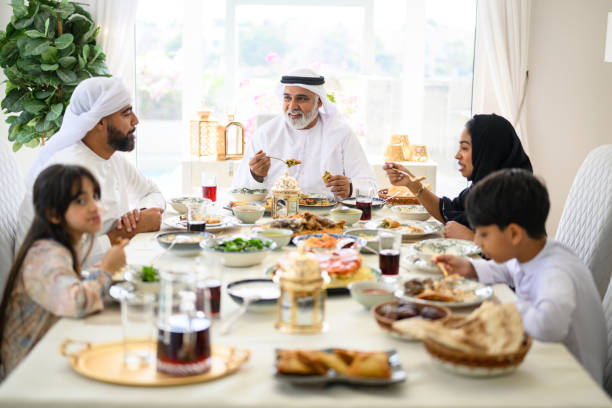 istock Three generation Emirati family sitting at dining table enjoying dinner, celebrating Eid-Ul-Fitr 2194403622