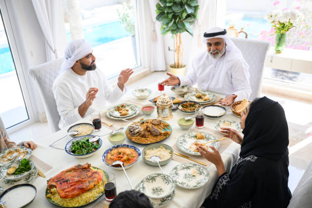 istock High angle of two Emirati men having discussion at dinner table with woman 2194403624
