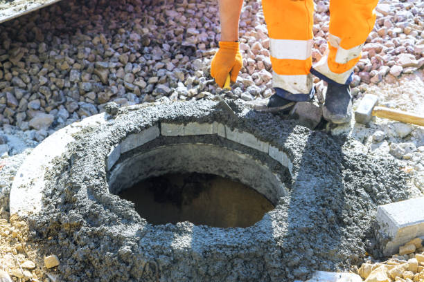 istock Forefront, fresh concrete is being applied to fix blocks at highest edge of a manhole for underground utilities. 2194404164