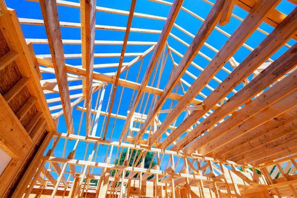 istock An open roof structure of wooden beams with progressing structural framework for skeletal frames on a large construction site 2194404223