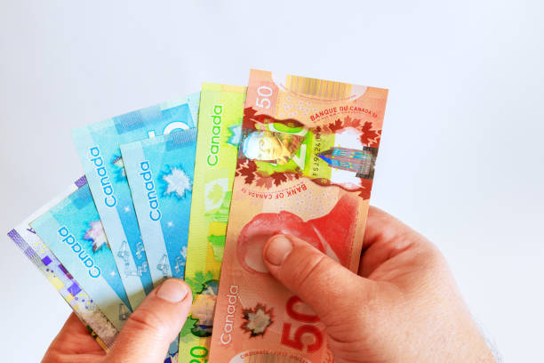 istock Hand holding a counting for Canadian dollar banknotes in various denominations 2194404265