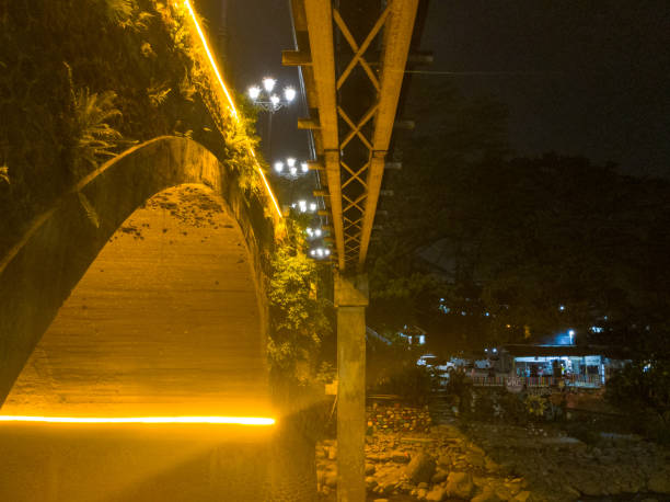 A nighttime view of an arched bridge, bathed in warm golden light