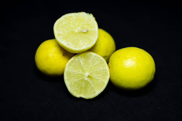 Hand squeezing lemon slice on white background.