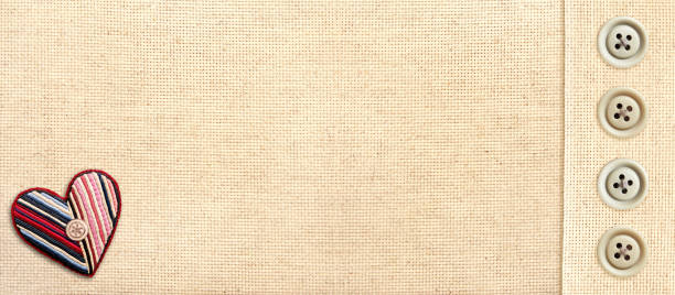 istock Horizontal Valentine's day background with beige canvas texture, buttons and felt heart in patchwork style. Natural linen eco texture backdrop with cozy decor. Copy space for text 2194408245