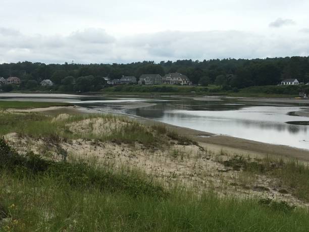 istock Inlet with grass covered sand dune & houses in background 2194410615