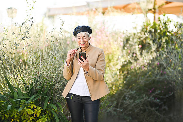 istock Smiling senior woman using smartphone in a garden 2194412569