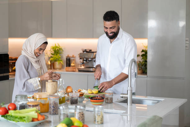 istock Arab husband and wife making meal together in kitchen, smiling 2194415863