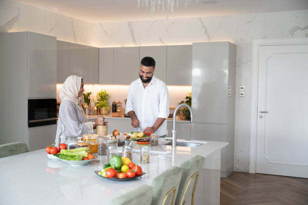 istock Arab couple preparing dinner in kitchen, man chopping ingredients, woman smiling and watching 2194415882
