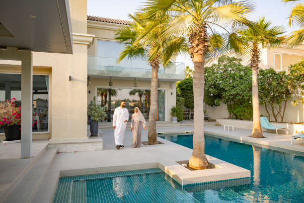 istock Arab couple walking by poolside outside luxury hotel 2194416177