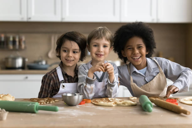 istock Three multiethnic boys in aprons cooking together in kitchen 2194420181
