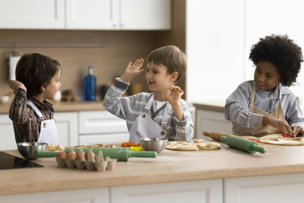 istock Little boys wear aprons cooking pizza together in modern kitchen 2194420258