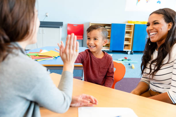 istock Happy Child Giving High Five to Teacher in Classroom 2194423050