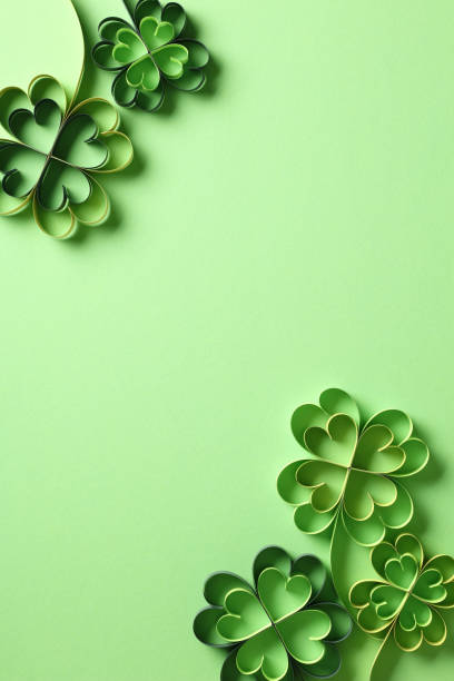 istock St Patricks Day vertical background, poster template. Flat lay paper cut clover leaves on green background. 2194425081