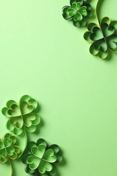 istock St. Patrick's Day vertical green background with paper cut clover leaves 2194425165