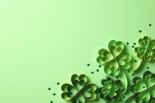 istock Happy St Patrick's Day concept. Flat lay composition with green paper cut clover leaves on green background. Top view, copy space 2194425355