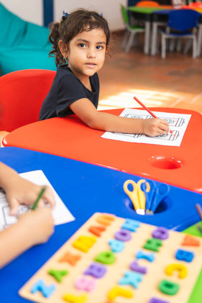 istock Preschool girl drawing with colored pencils at desk 2194427621