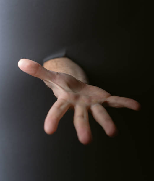 istock photo Outstretched hand reaching through a dark space symbolizing connection, trust, help, communication, and empathy amidst unknown challenges in human relationships 2194430973