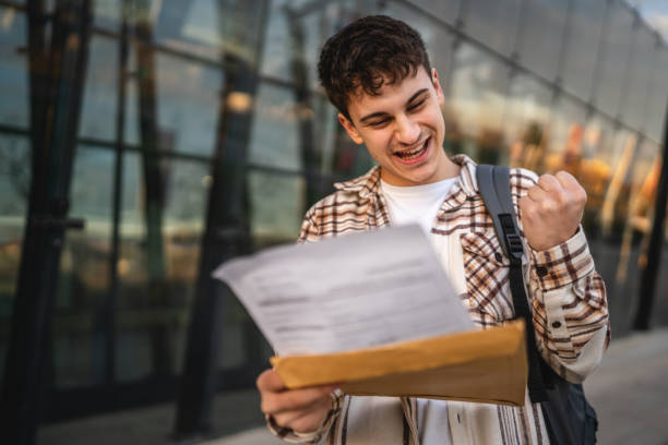 istock Young adult man student open and read files from envelope outdoor 2194431848