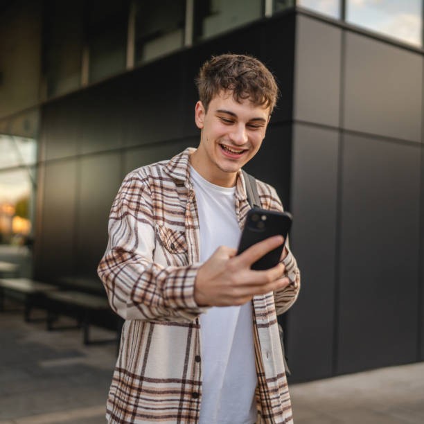 istock young man stand in front modern building and use mobile phone 2194432508
