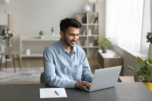 istock Indian businessman, freelance worker sits at desk working on-line 2194432635