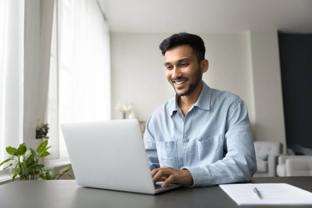 istock Smiling Indian man enjoy remote online work at home 2194432696