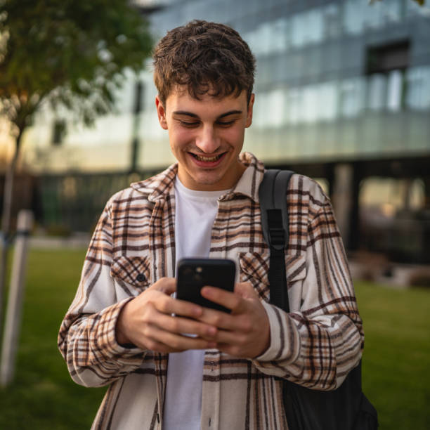 istock young man stand in front modern building and use mobile phone 2194432987