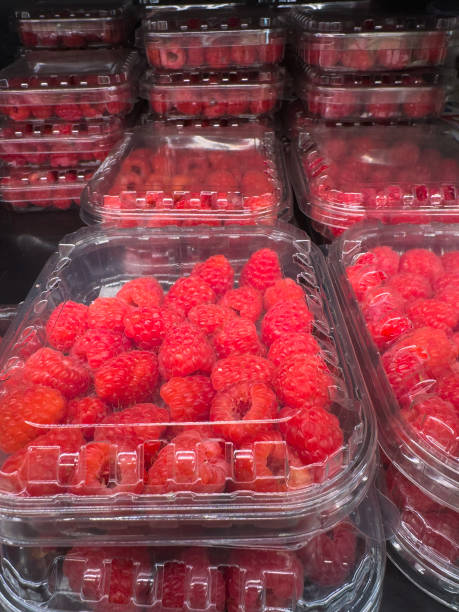 istock Juicy raspberries packed in plastic containers at the mall, close-up view. 2194439312