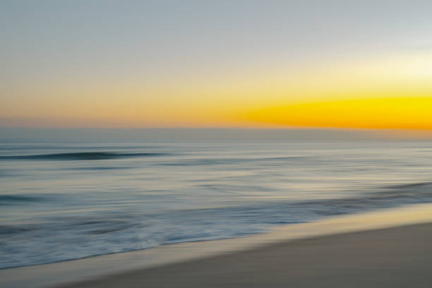 istock Tranquil waves flow beneath the fading colors of a serene sunset. 2194439363