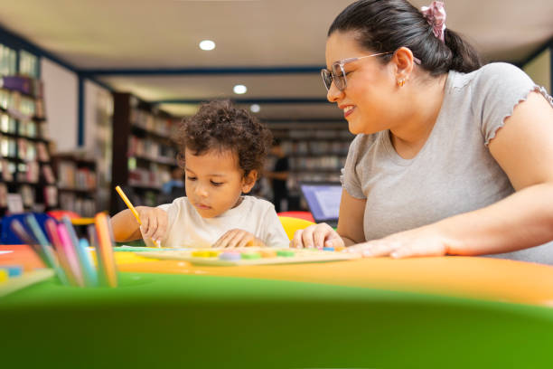istock Mother and child drawing together in library 2194441097