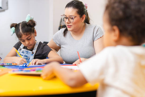 istock Teacher helping elementary age girl with art project in classroom 2194441456