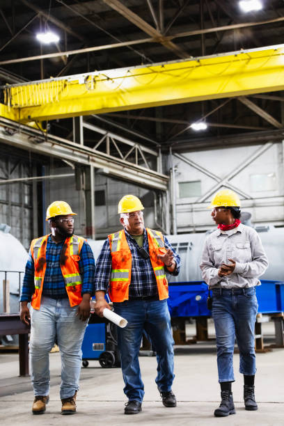 istock Three workers conversing in steel fabrication factory 2194444395
