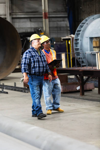 istock Two multiracial workers in factory with digital tablet 2194444440