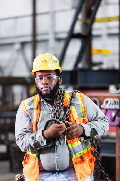 istock Worker in warehouse carrying chain sling for crane 2194444508