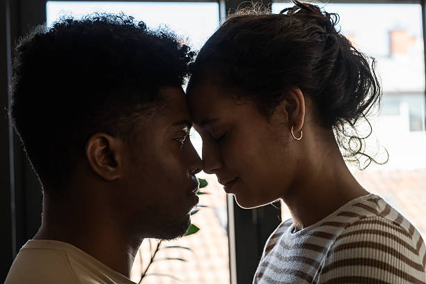 istock A close and intimate moment as a couple gently touches foreheads, sharing a quiet connection in soft natural light 2194446191