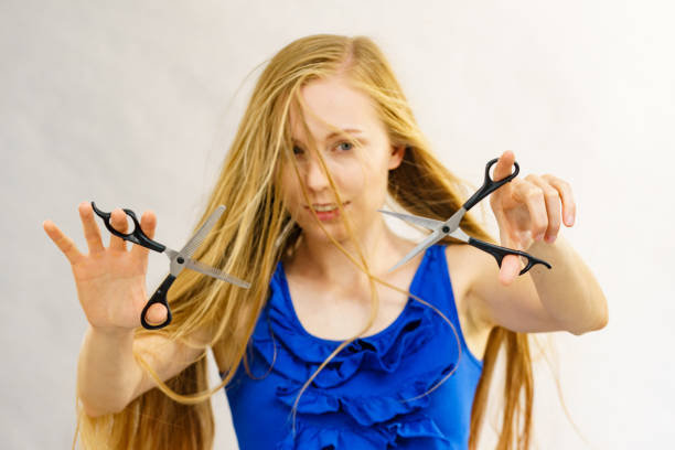 istock Girl with scissors for haircutting 2194447137
