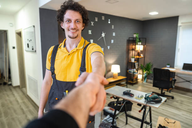Smiling handyman shaking hands after finishing a home repair work
