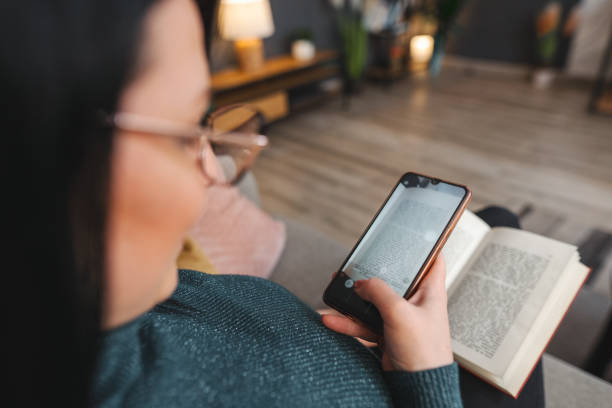 istock Woman is scanning text from book with her smartphone 2194447959