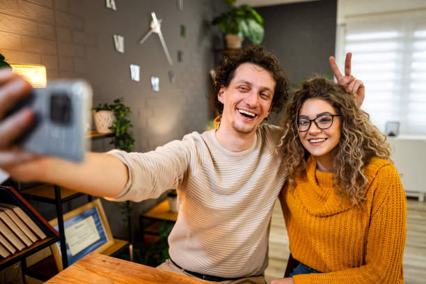 istock Cheerful couple taking a selfie at home, making funny faces 2194447980
