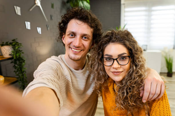 istock Happy couple taking a selfie at home smiling and embracing 2194448149