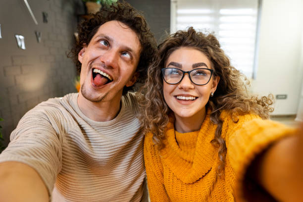 istock Young couple making funny faces taking a selfie at home 2194448164