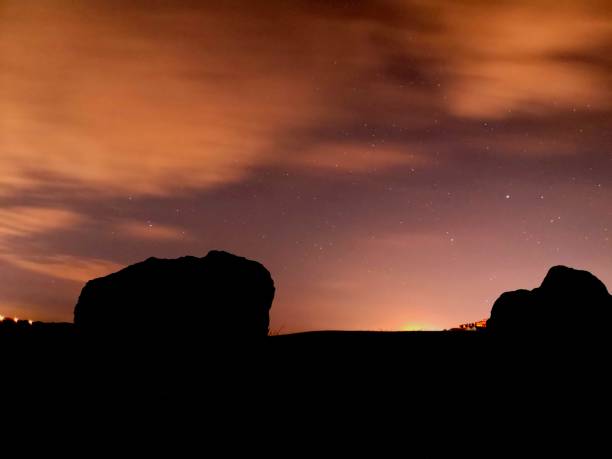 istock A dramatic sunset with stars visible with the foreground rocks in silhouette 2194448869