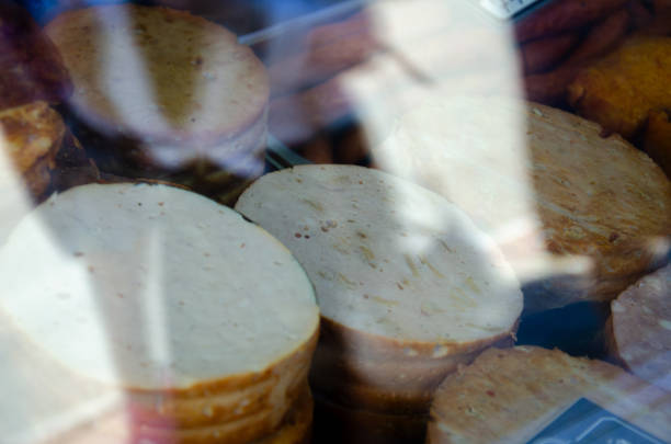 A showcase with sausage and meat products behind glass