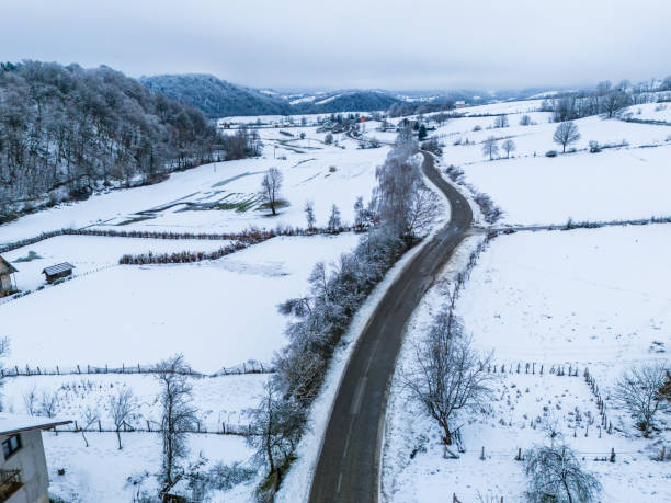 Winding Winter Road Through Snow-Covered Countryside and Hills