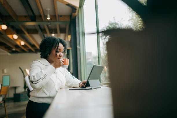 istock Woman Working on Tablet Computer At Coffee Shop 2194458128