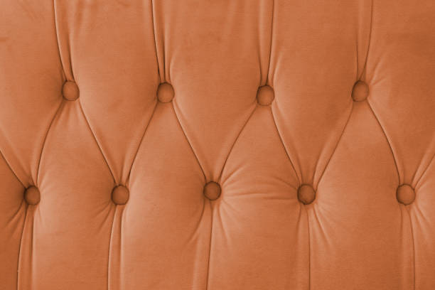 istock Capitone, Chesterfield style suede fabric texture, orange diamond buttoned orange background 2194462279