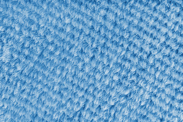Terry cloth, diagonal striped pattern blue towel texture background. Soft fluffy textile bath or microfiber beach towel material. Top view, close up, macro.