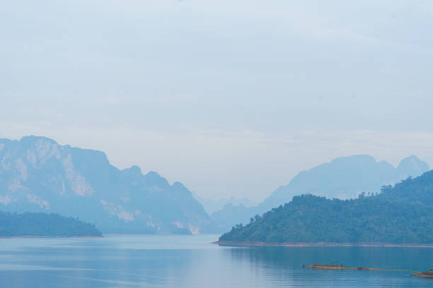 A Serene landscape with misty mountains and calm water reflections